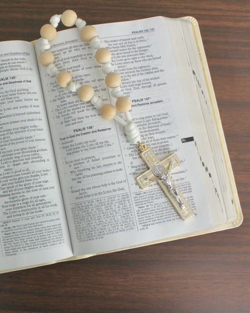 Handmade one decade door rosary by Knots of Grace, Light of Faith St. Benedict Door Rosary, white (pictured on bible)