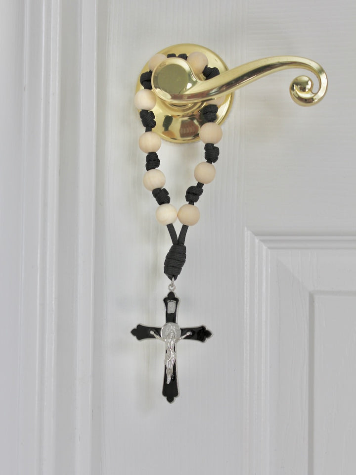 St. Michael Faithful Defender Door Rosary hanging on a brass door handle with natural wood beads and black cord