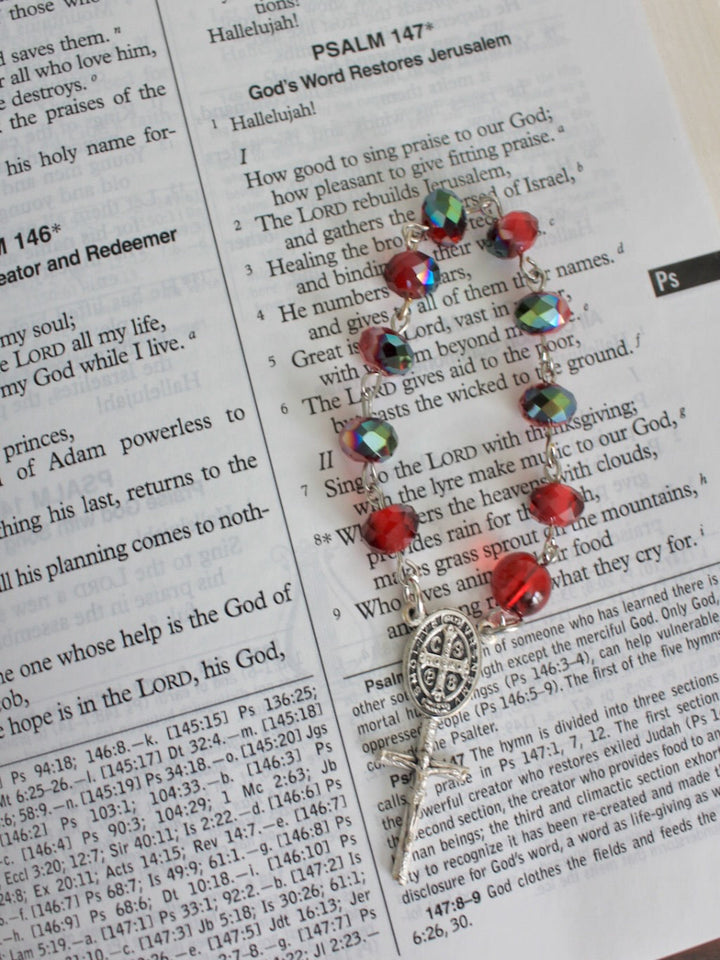 Decorative small rosary with colorful beads on a Bible page